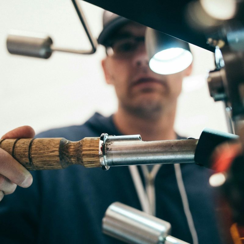 man wearing black pullover hoodie holding tool